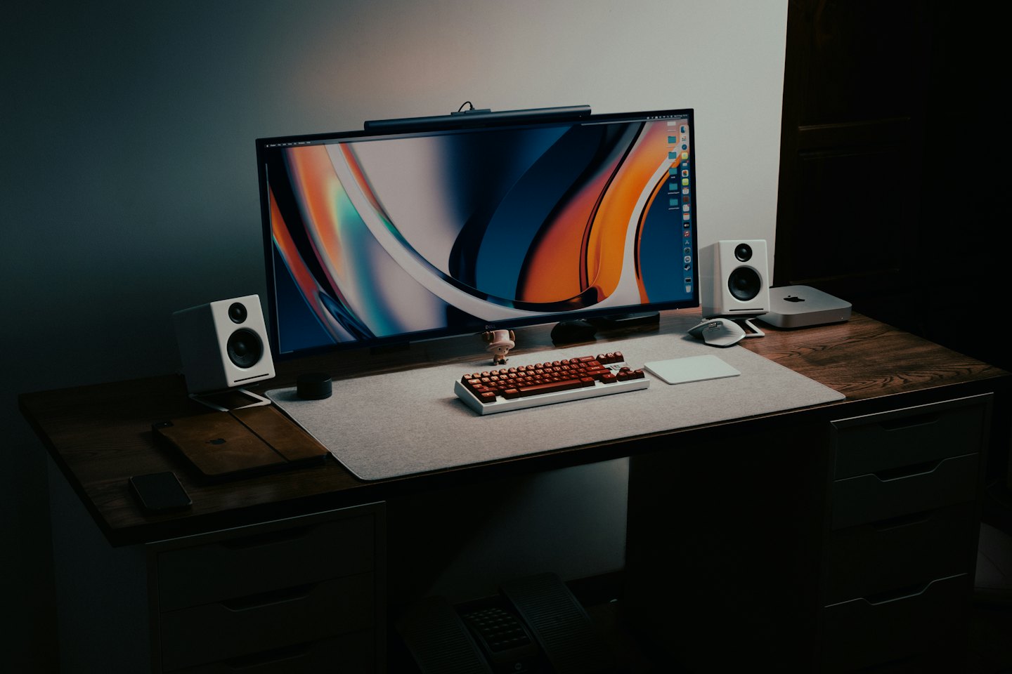 Minimalist desk with computer monitor, speakers, and peripherals on wood.
